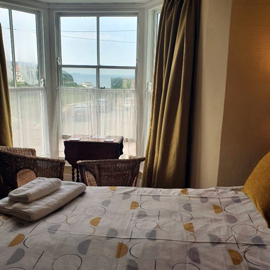 B&B in Little Haven and Wales yellow room décor and wicker chairs by bay window overlooking Pembrokeshire Coast Path