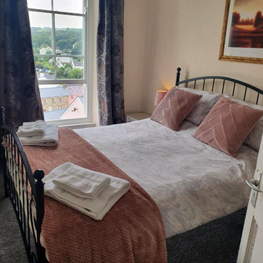 B&B in Little Haven and Wales double room with pink and cream décor and view of Little Haven through window